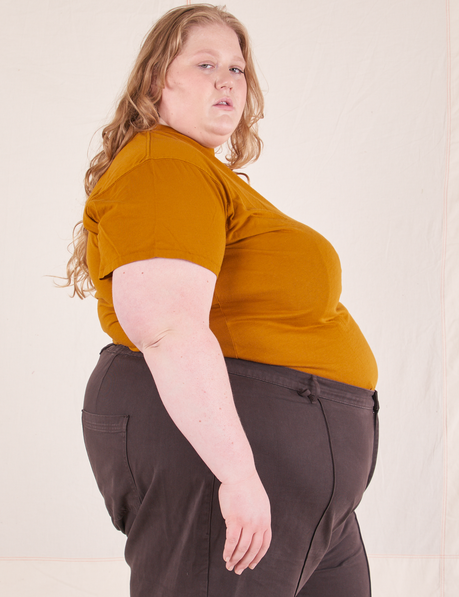 Side view of Organic Vintage Tee in Spicy Mustard and espresso brown Western Pants worn by Catie
