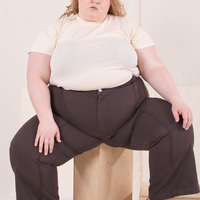 The Organic Vintage Tee in Vintage Off White on Catie wearing espresso brown Western Pants sitting on wooden crate