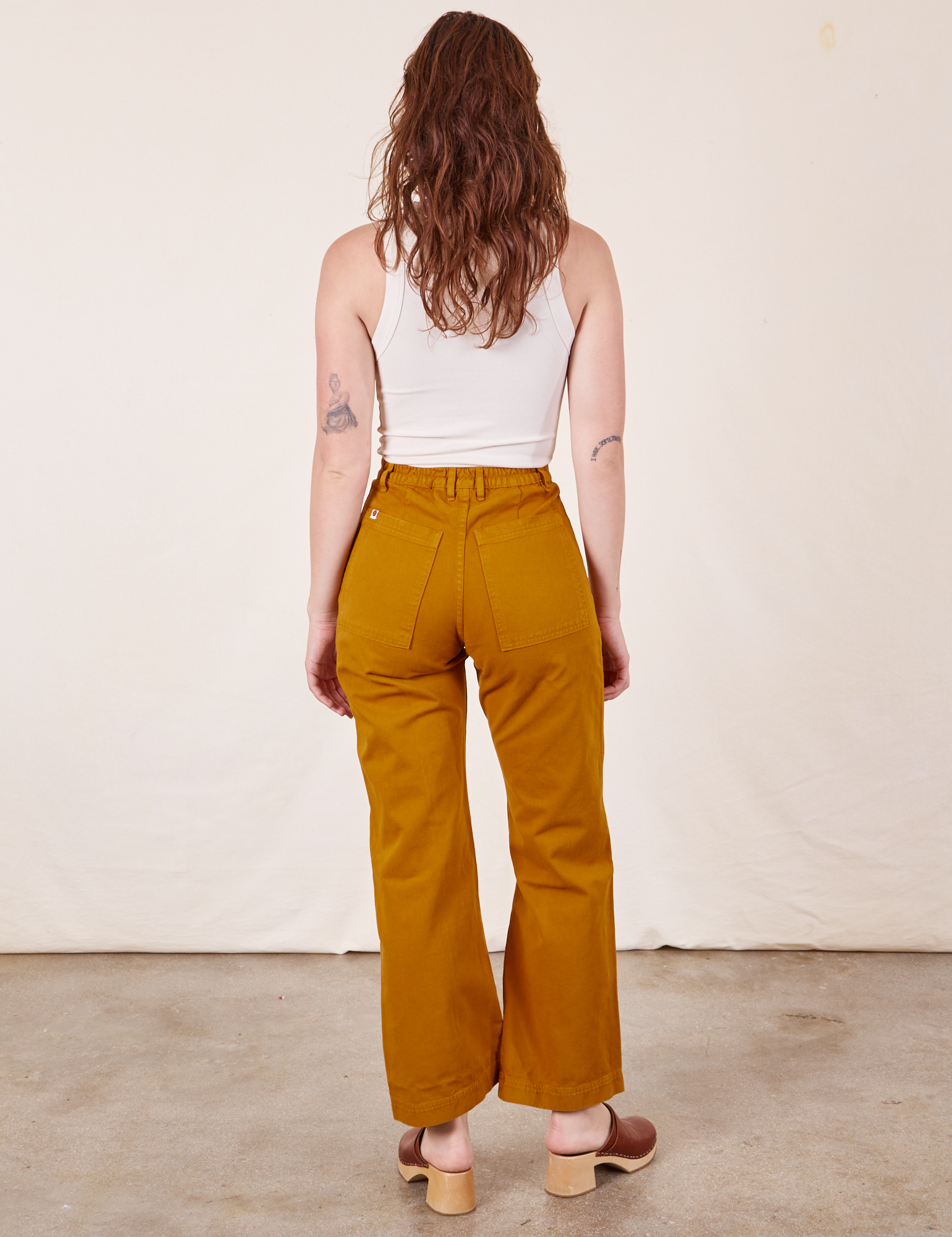 Back view of Western Pants in Spicy Mustard and vintage off-white Tank Top on Alex