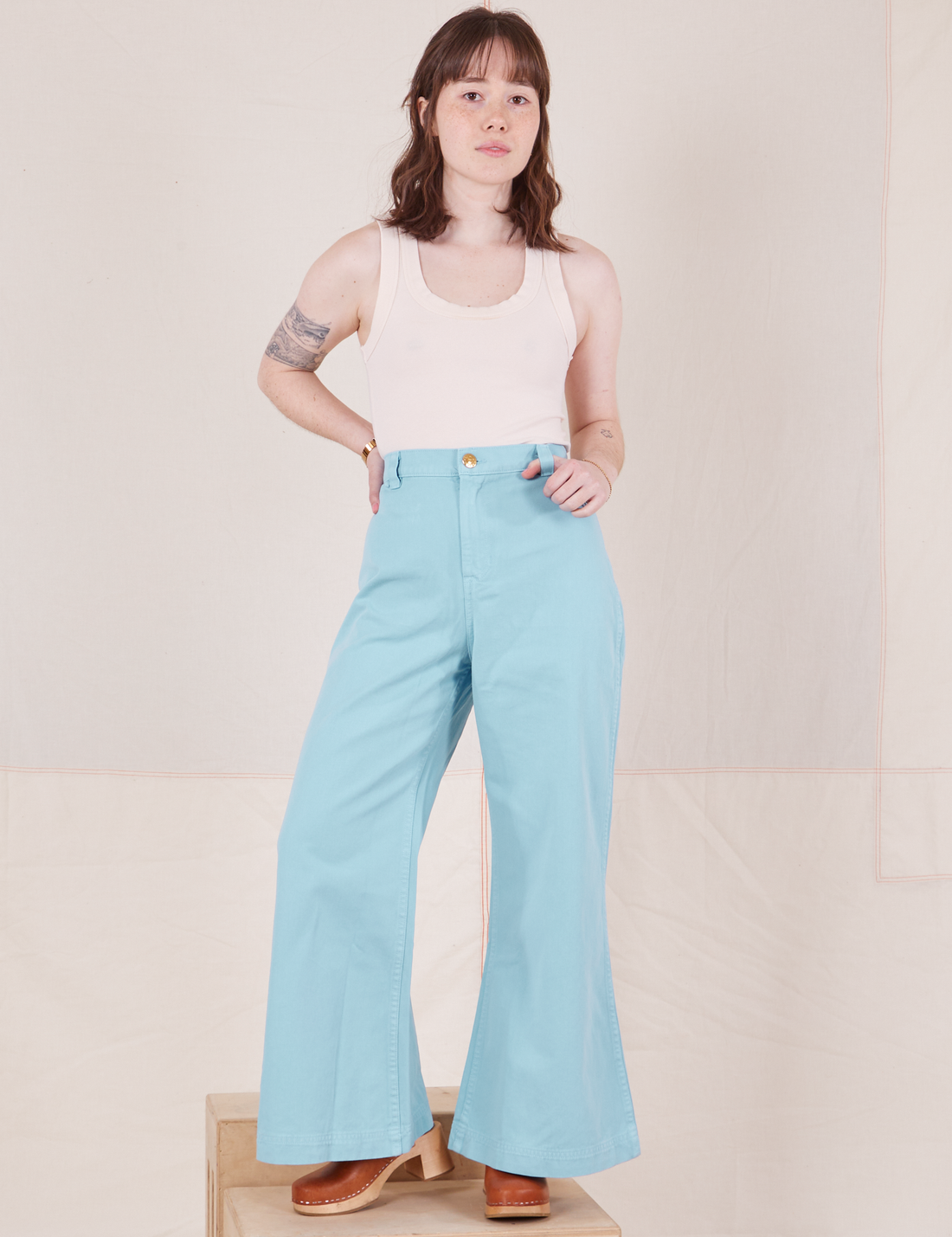 Hana is 5'3" and wearing XXS Bell Bottoms in Baby Blue paired with vintage off-white Tank Top