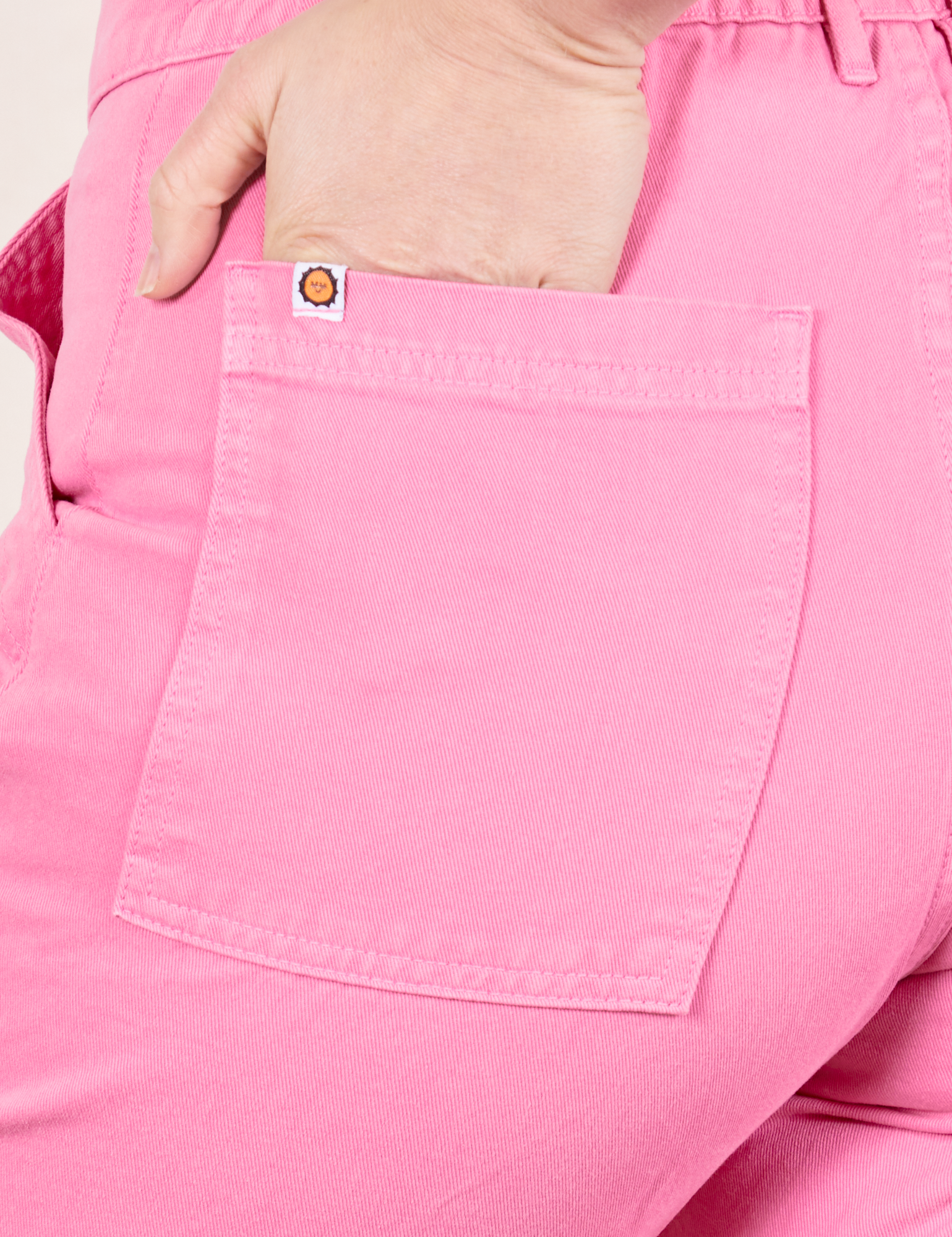 Work Pants in Bubblegum Pink back pocket close up. Worn by Allison with hand in pocket.