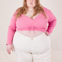 Catie is wearing size 6 Wrap Top in Bubblegum Pink paired with vintage off-white Western Pants