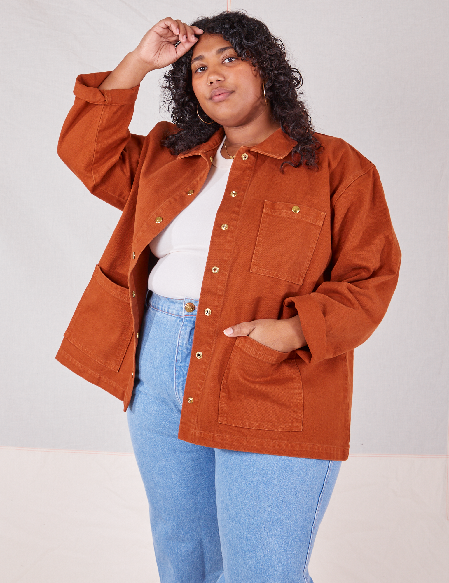 Morgan is wearing Denim Work Jacket in Burnt Terracotta. She has one hand in the front pocket