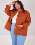 Morgan is wearing Denim Work Jacket in Burnt Terracotta. She has one hand in the front pocket