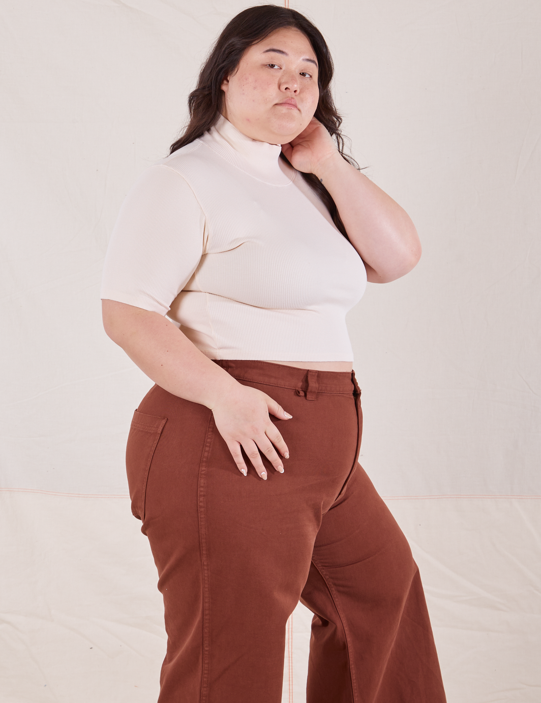 Side view on Ashley wearing 1/2 Sleeve Essential Turtleneck in Vintage Off White and fudgesicle brown Bell Bottoms