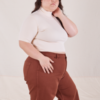 Side view on Ashley wearing 1/2 Sleeve Essential Turtleneck in Vintage Off White and fudgesicle brown Bell Bottoms