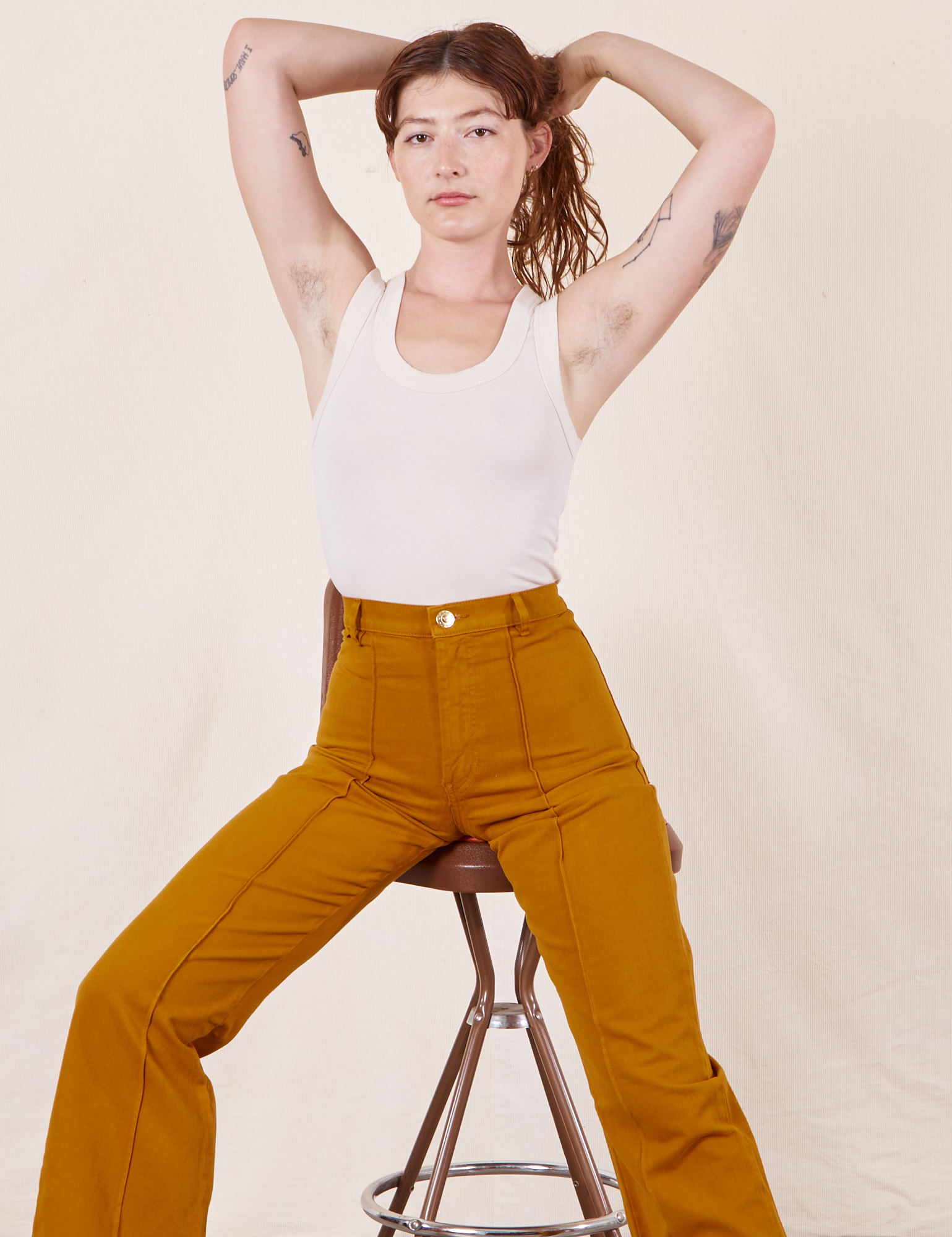 Alex is wearing Western Pants in Spicy Mustard and vintage off-white Tank Top
