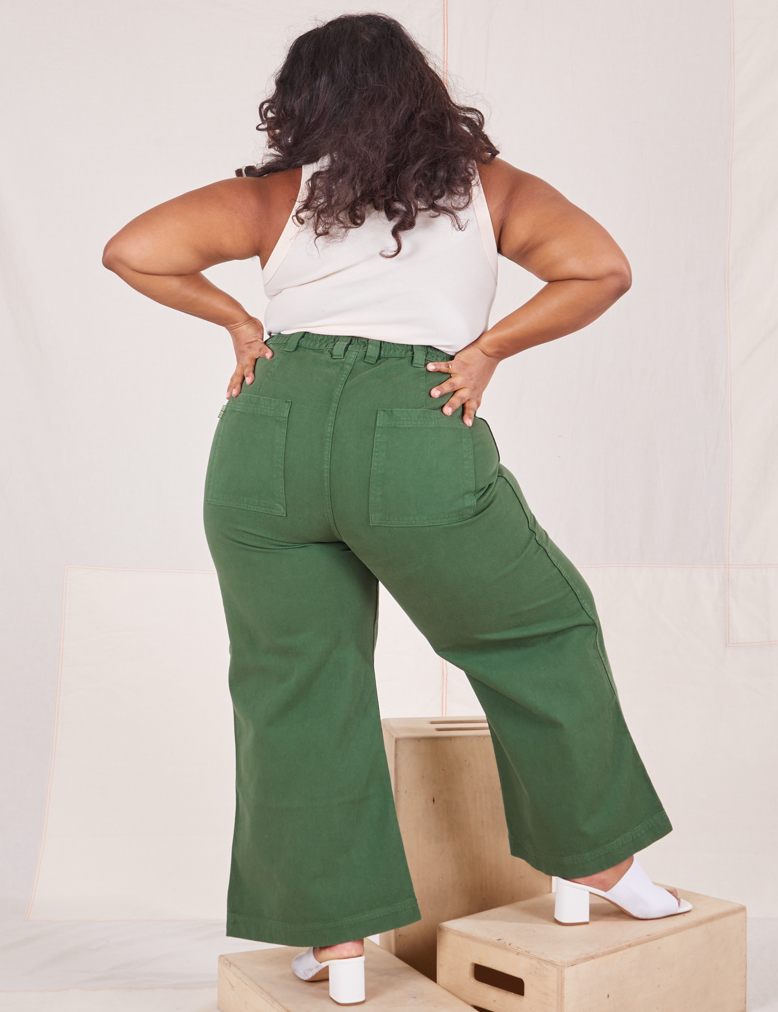 Back view of Bell Bottoms in Dark Emerald Green and vintage off-white Tank Top worn by Morgan