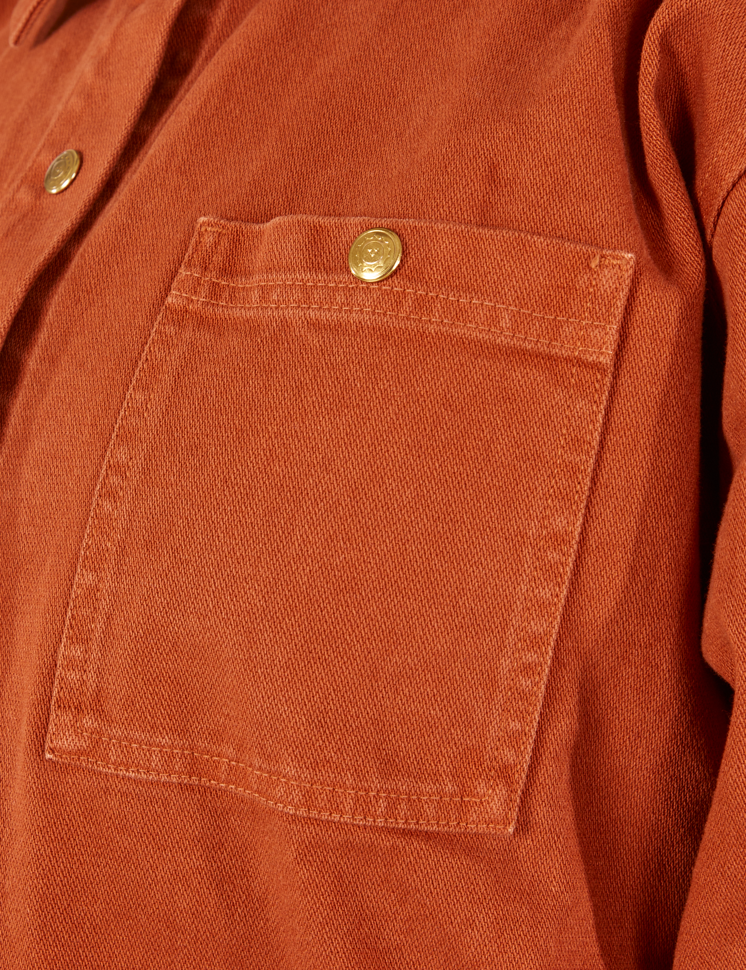 Denim Work Jacket in Burnt Terracotta front pocket close up with sun baby brass button