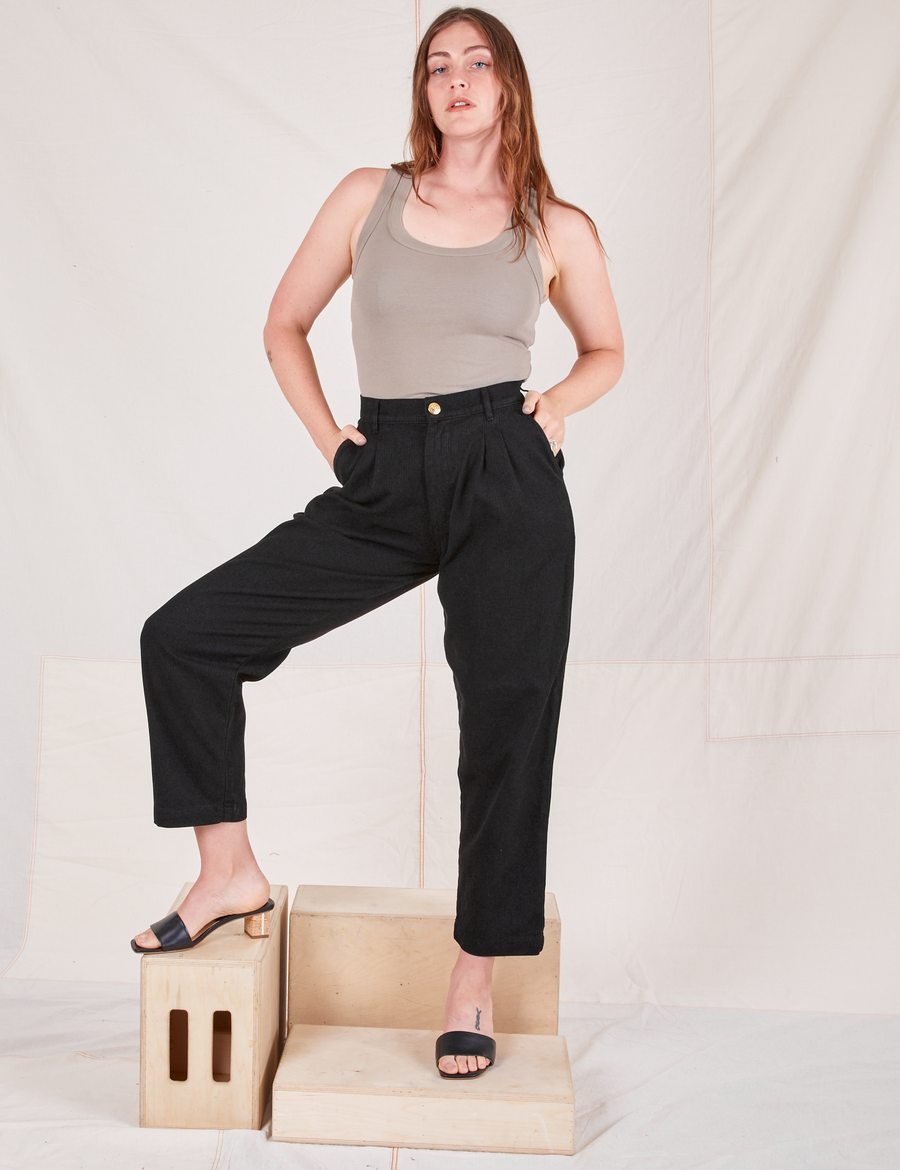 Allison is 5'10" and wearing S Heritage Trousers in Basic Black paired with khaki grey Tank Top