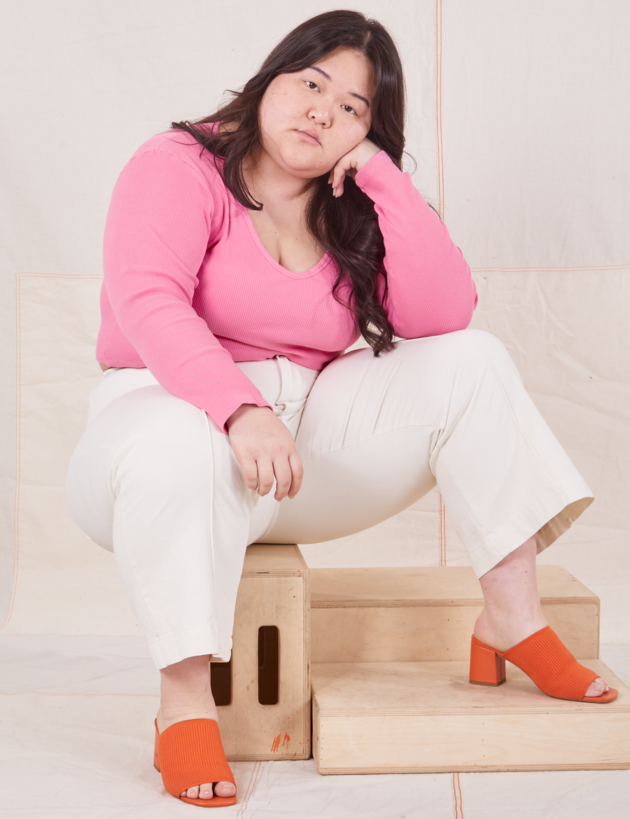  Long Sleeve V-Neck Tee in Bubblegum on Ashley wearing vintage off-white Western Pants sitting on wooden crate