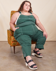 Original Overalls in Dark Emerald Green on Mara sitting in patterned chair