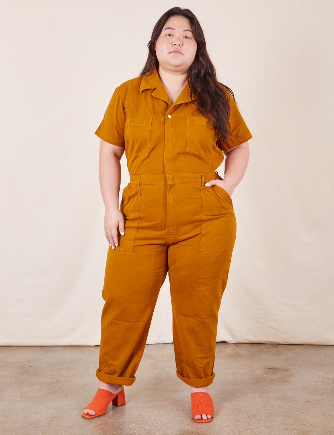 Ashley is 5'7" and wearing 1XL Short Sleeve Jumpsuit in Spicy Mustard