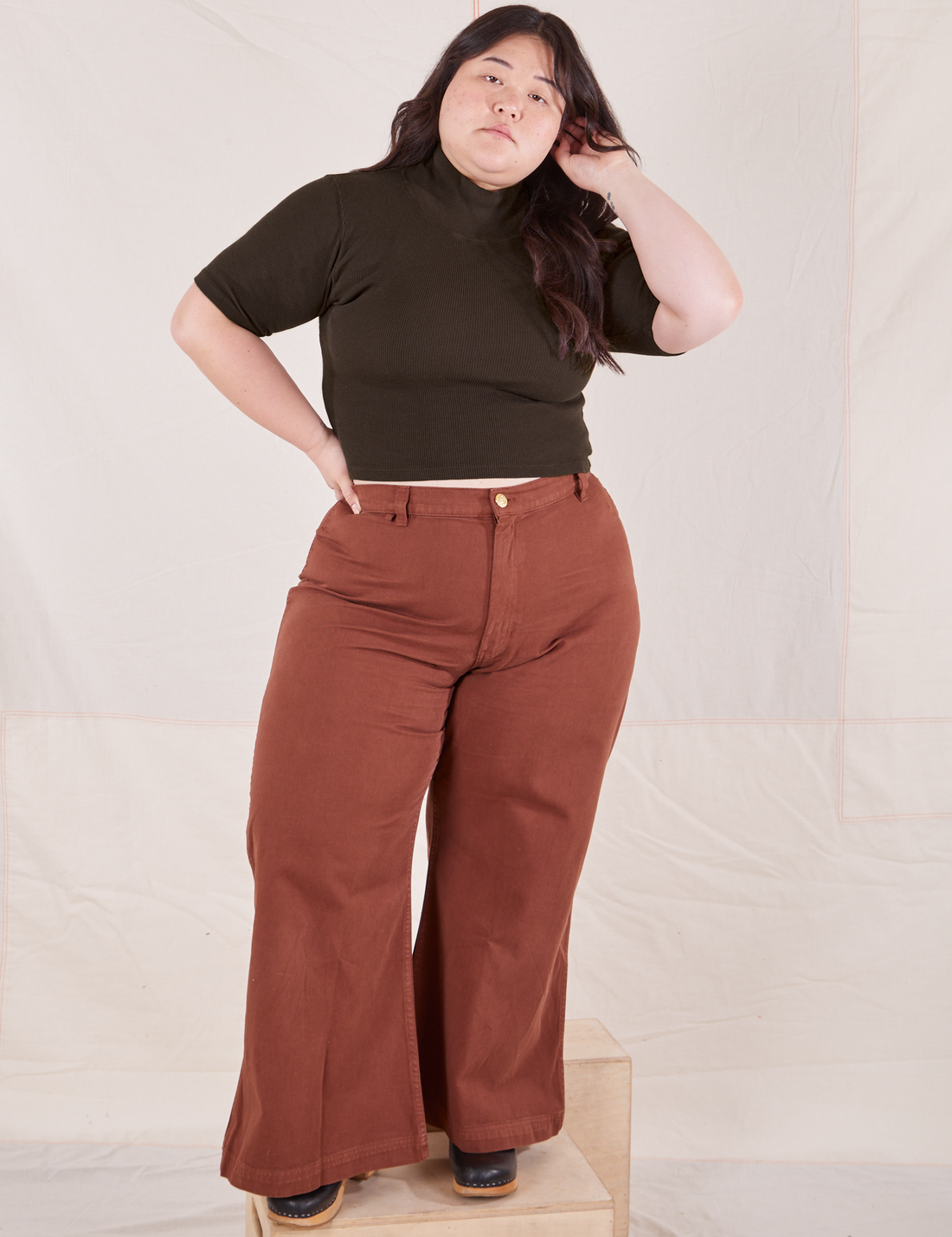 Ashley is wearing size M 1/2 Sleeve Essential Turtleneck in Espresso Brown paired with fudgesicle brown Bell Bottoms
