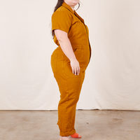 Side view of Short Sleeve Jumpsuit in Spicy Mustard worn by Ashley