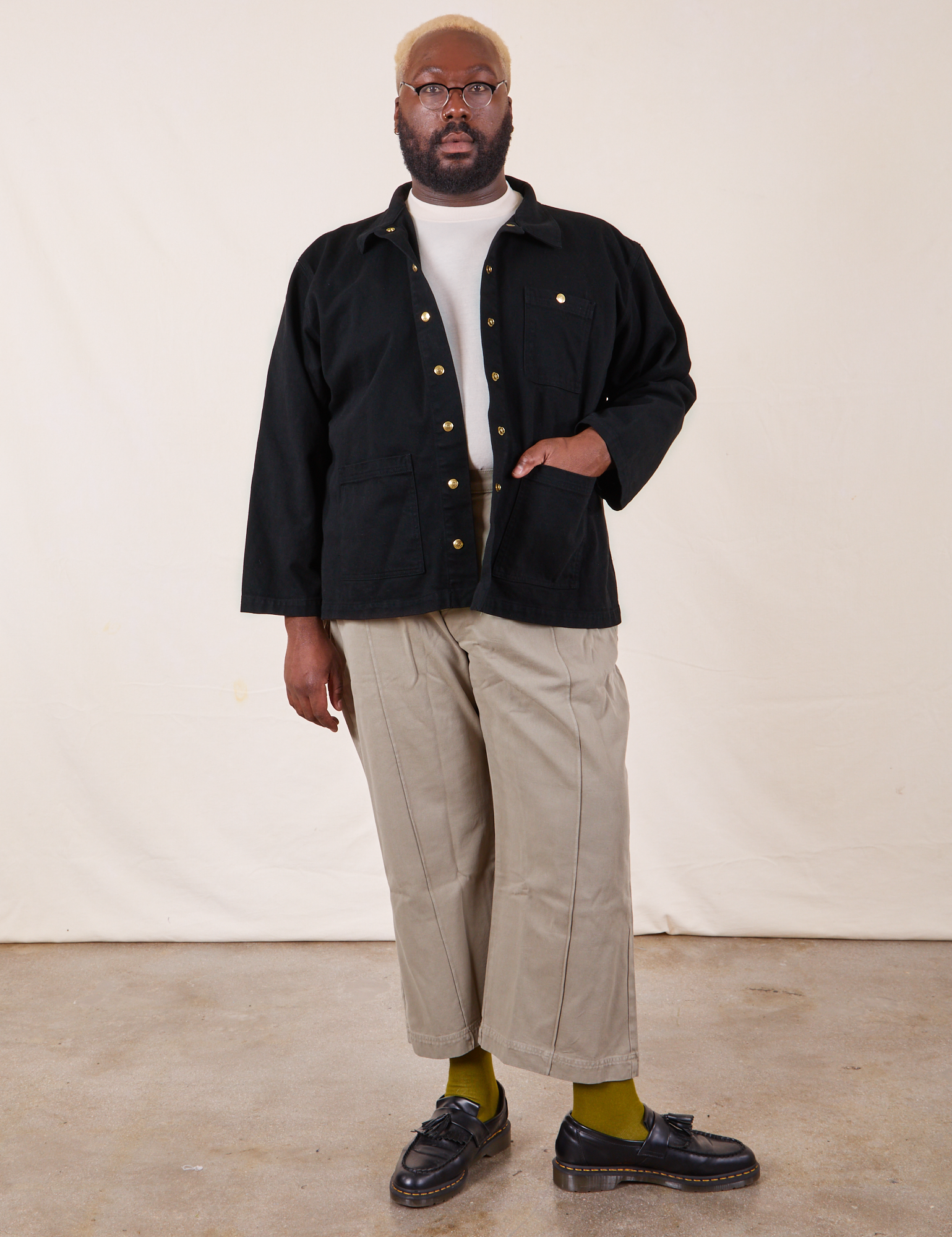 Elijah is 6&#39;4&quot; and wearing 3XL Denim Work Jacket in Basic Black paired with khaki gray Western Pants. He has his right hand in the jacket pocket.