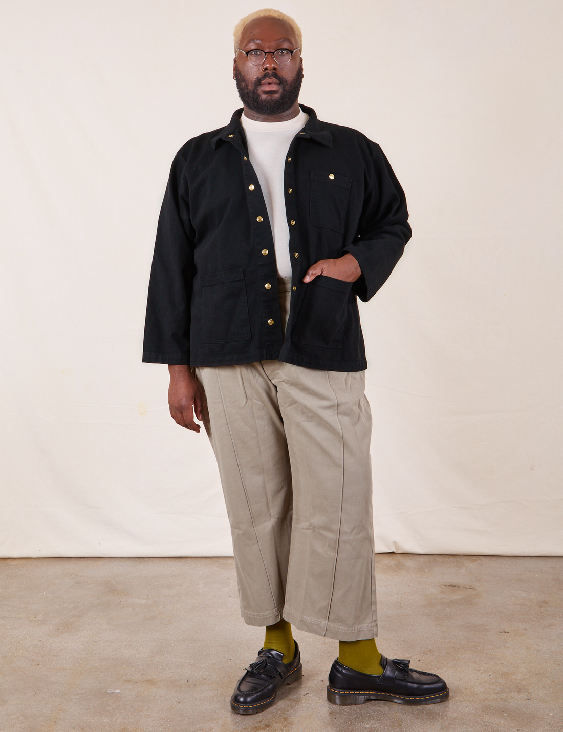 Elijah is 6'4" and wearing 3XL Denim Work Jacket in Basic Black paired with khaki gray Western Pants. He has his right hand in the jacket pocket.