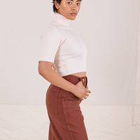 Side view of Mika wearing 1/2 Sleeve Essential Turtleneck in Vintage Off White and fudgesicle brown Bell Bottoms