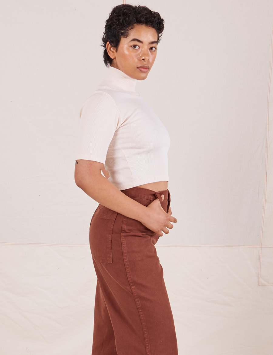 Side view of Mika wearing 1/2 Sleeve Essential Turtleneck in Vintage Off White and fudgesicle brown Bell Bottoms