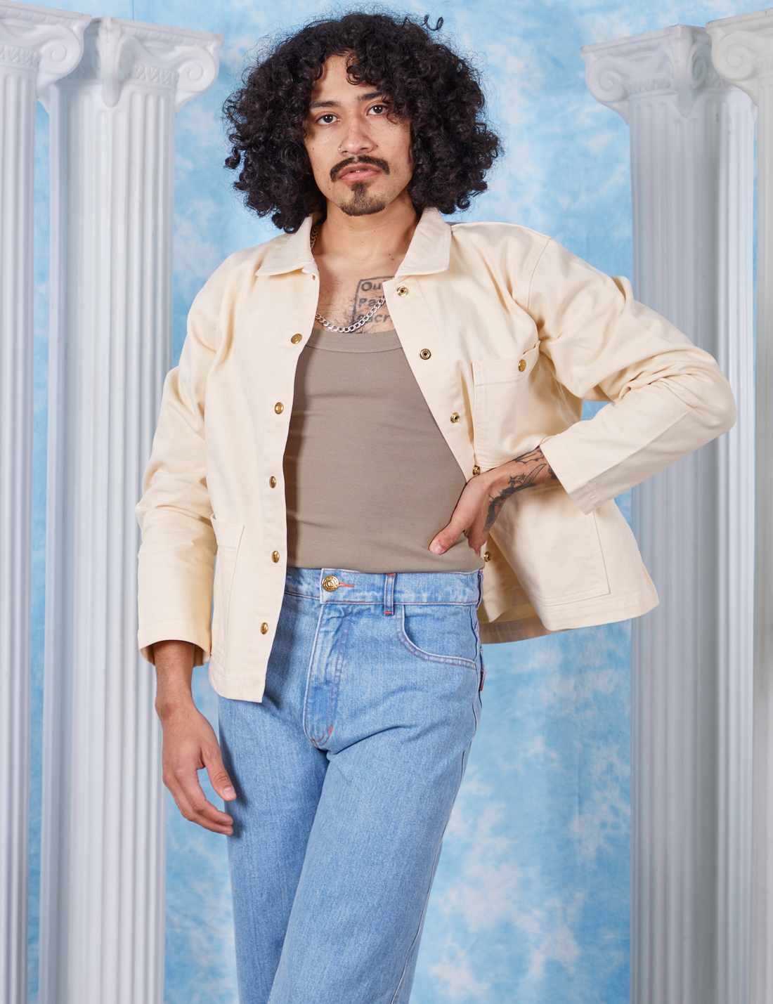 Jesse is wearing size S Vintage off-white David Neoclassical Work Jacket paired with khaki grey Tank Top underneath