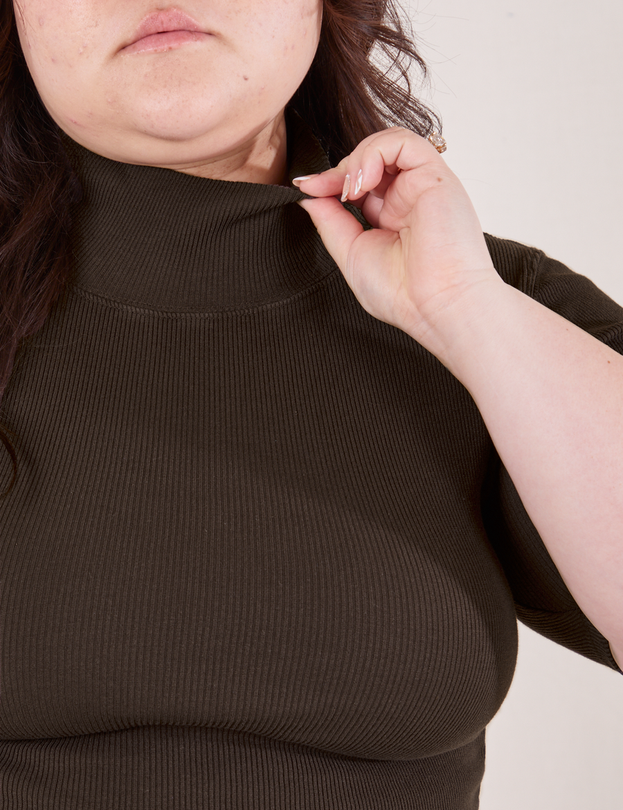 Front close up of 1/2 Sleeve Essential Turtleneck in Espresso Brown. Ashley is holding the edge of the turtleneck.