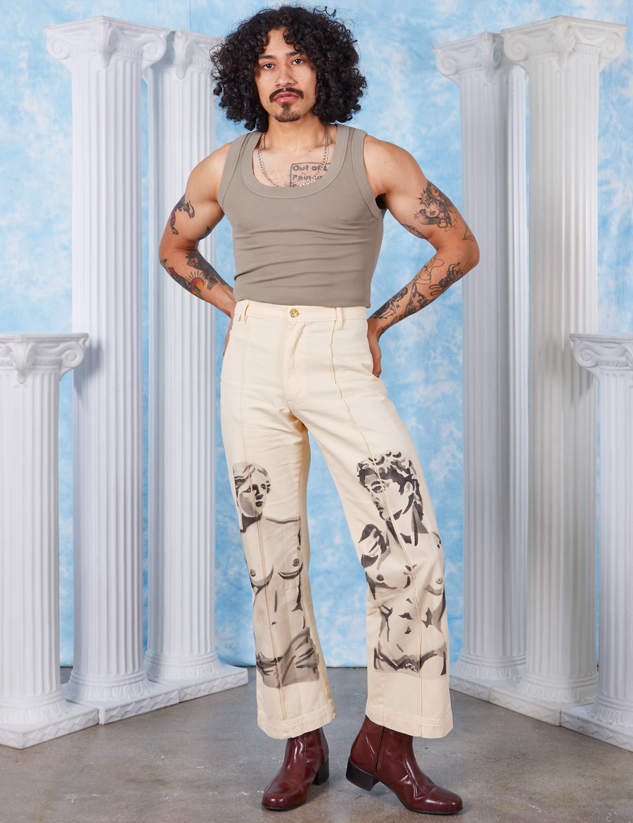 Jesse is 5'8" and wearing XS Venus & David Airbrush Western Pants paired with khaki grey Tank Top