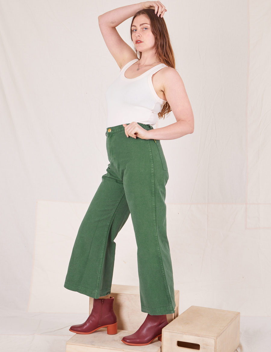 Side view of Bell Bottoms in Dark Emerald Green and vintage off-white Tank Top worn by Allison