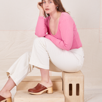  Long Sleeve V-Neck Tee in Bubblegum on Allison wearing vintage off-white Western Pants sitting on wooden crate
