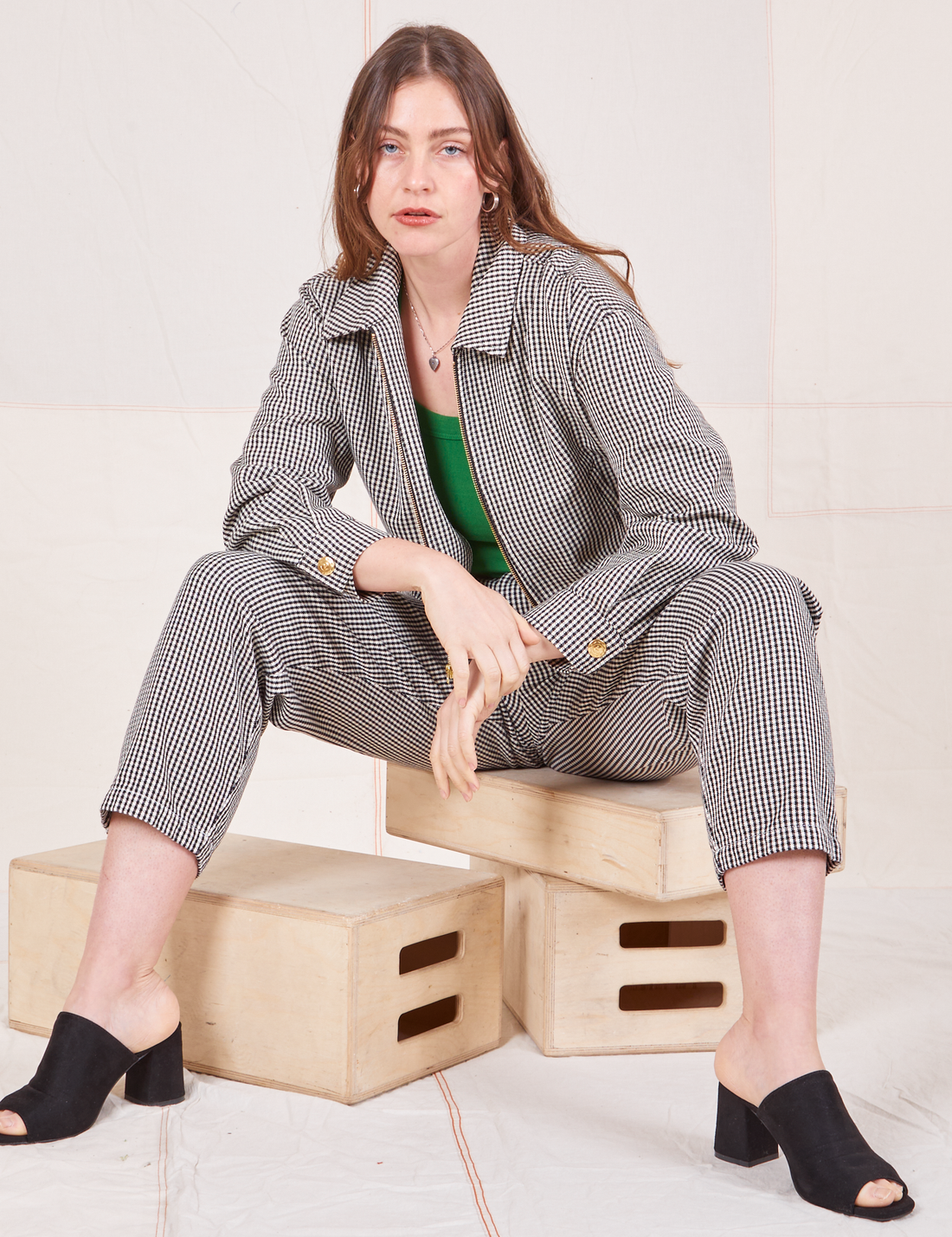 Ricky Jacket in Black & White Checker on Allison wearing matching trousers sitting on wooden crate