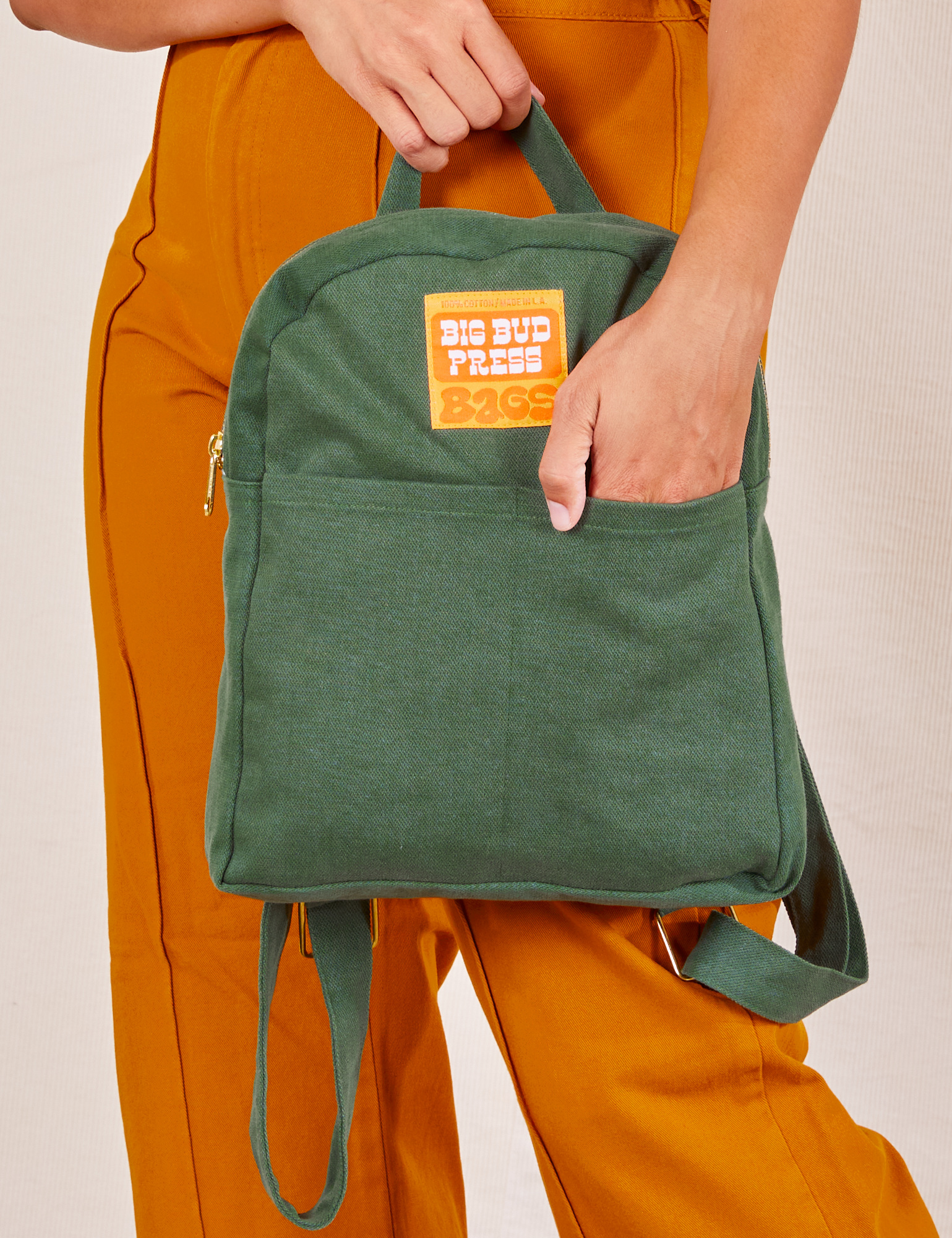 Mini Backpack in Dark Emerald Green held by Tiara