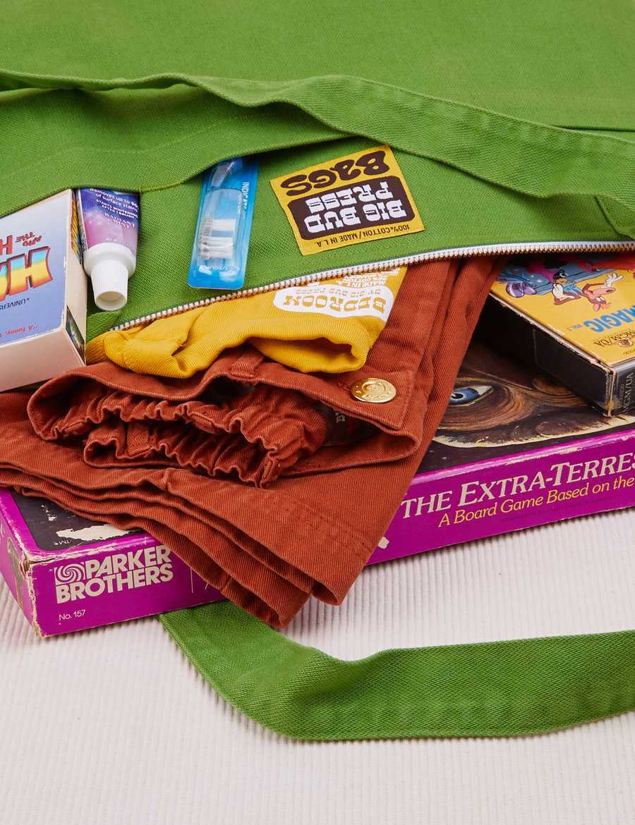 XL Zip Tote in Bright Olive close up packed with clothing and board games
