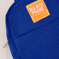 Mini Backpack in Royal Blue close up with orange and yellow Big Bud Press label