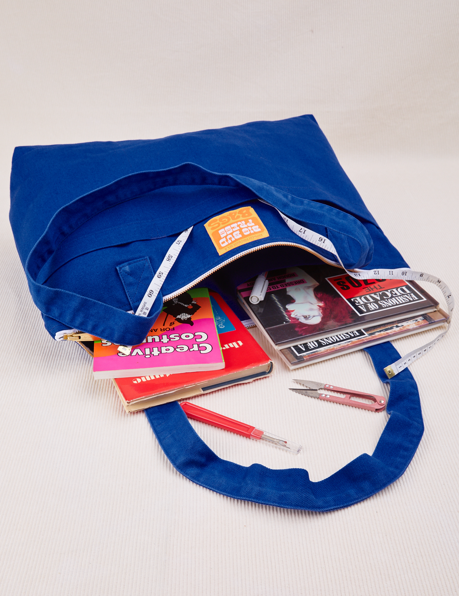 XL Zip Tote in Royal Blue packed with books and magazines