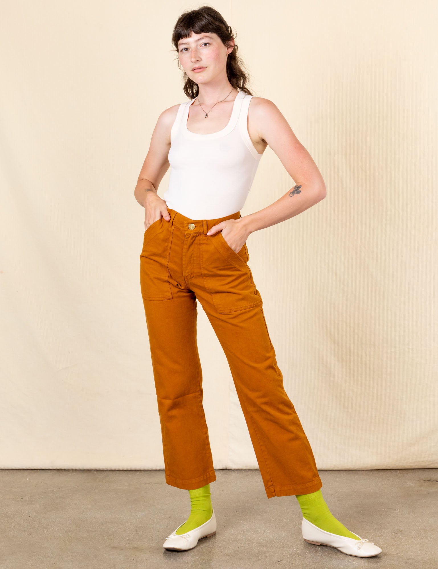 Alex is 5&#39;8&quot; and wearing XS Work Pants in Spicy Mustard paired vintage off-white Tank Top