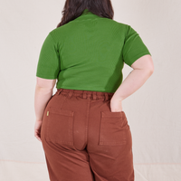 1/2 Sleeve Essential Turtleneck in Bright Olive back view on Ashley wearing fudgesicle brown Bell Bottoms. Ashley has her hand in the back pocket.