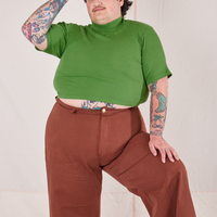 Sam is wearing 1/2 Sleeve Essential Turtleneck in Bright Olive and fudgesicle brown Bell Bottoms