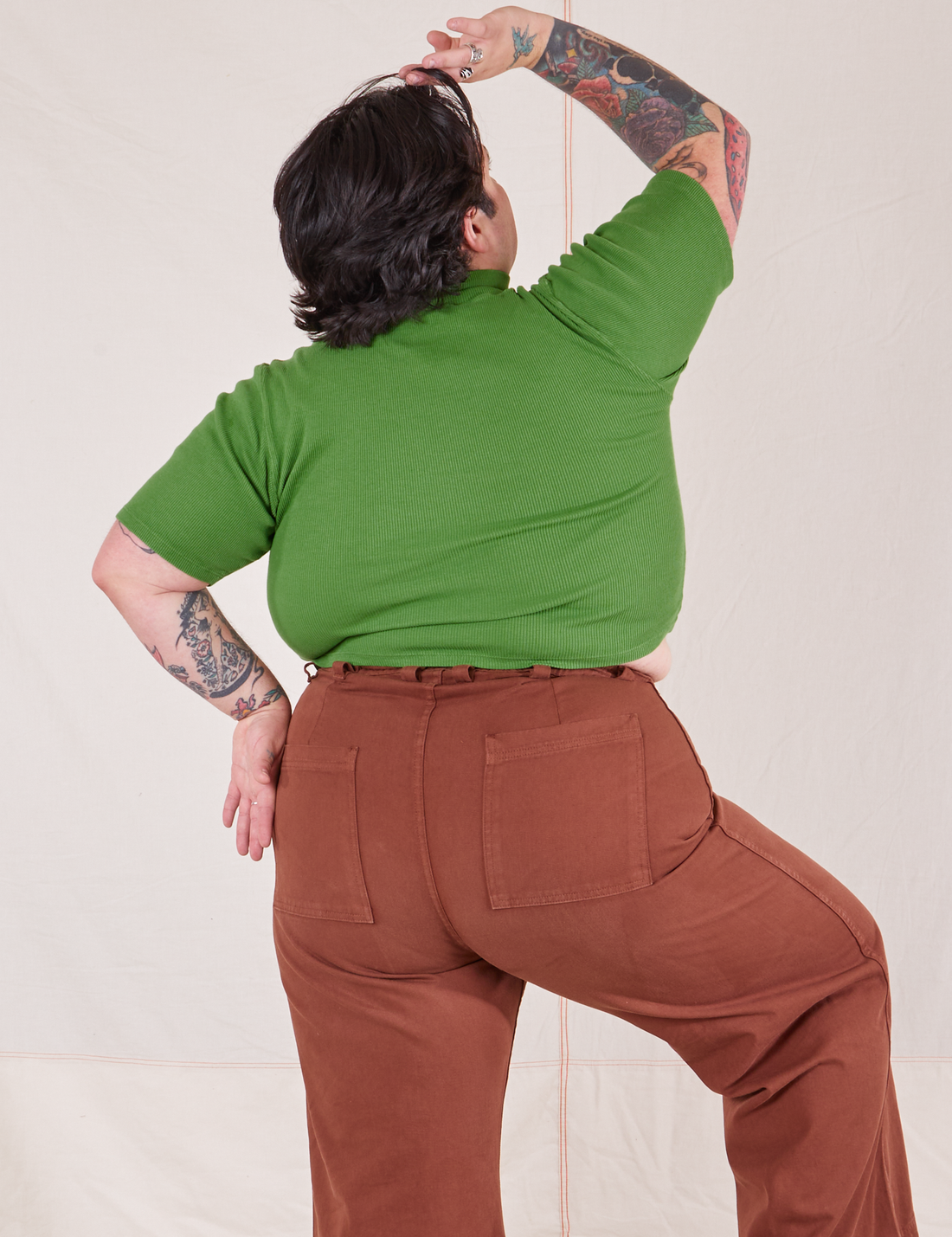 Back view of 1/2 Sleeve Essential Turtleneck in Bright Olive and fudgesicle brown Bell Bottoms worn by Sam