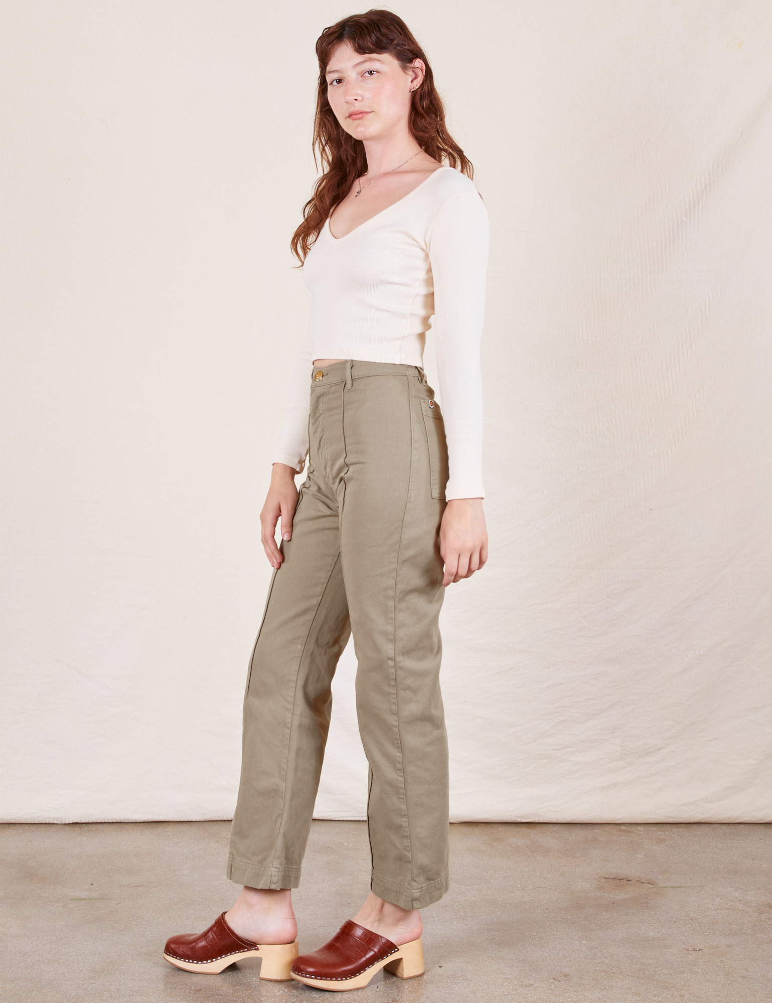 Alex is 5&#39;8&quot; and wearing XS Western Pants in Khaki Grey paired with a vintage off-white Long Sleeve V-Neck Tee