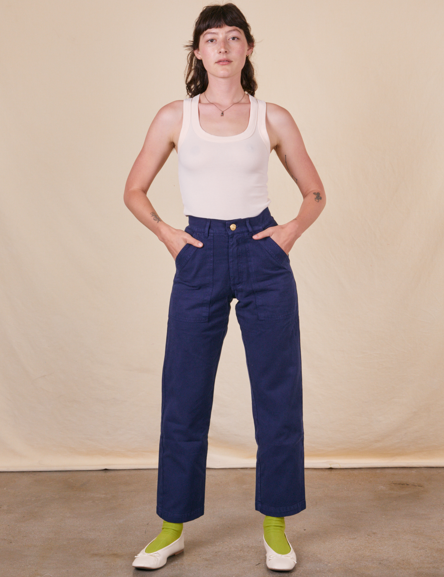 Alex is 5&#39;8&quot; and wearing XS Work Pants in Navy Blue paired with vintage off-white Tank Top