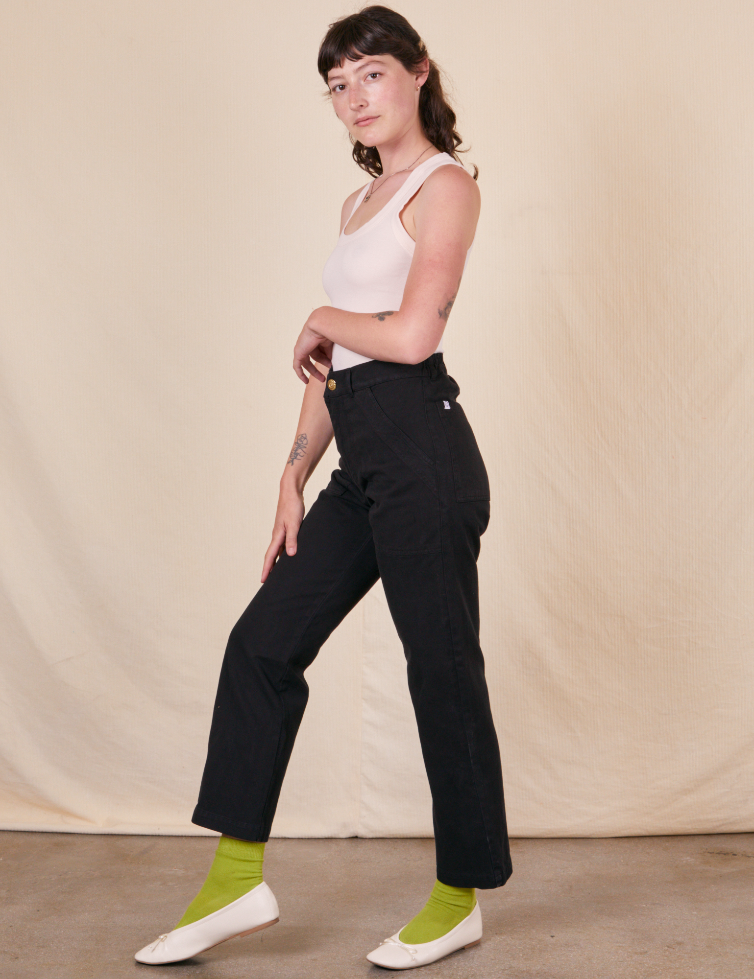 Side view of Work Pants in Basic Black and vintage off-white Tank Top on Alex