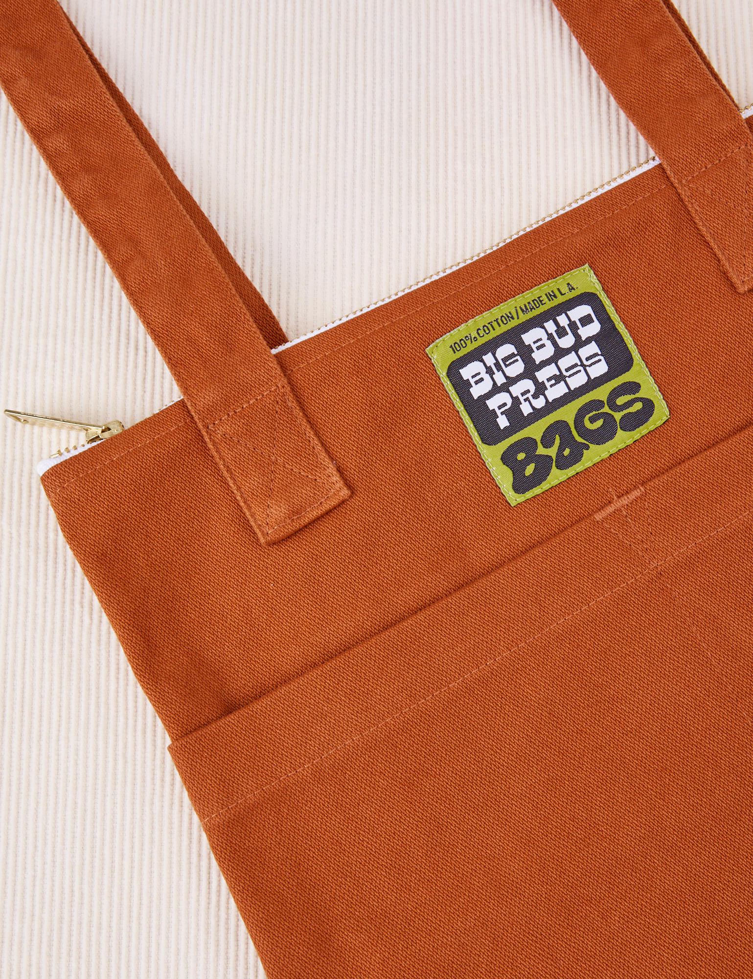 Over-Shoulder Zip Mini Tote in Burnt Terracotta close up with green Big Bud Press label