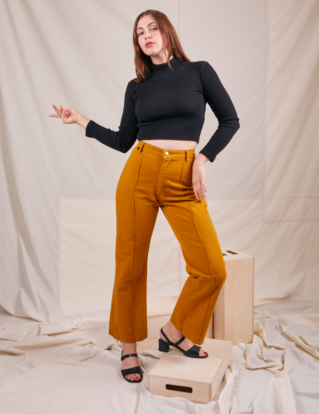 Allison is wearing Essential Turtleneck in Basic Black and spicy mustard Western Pants