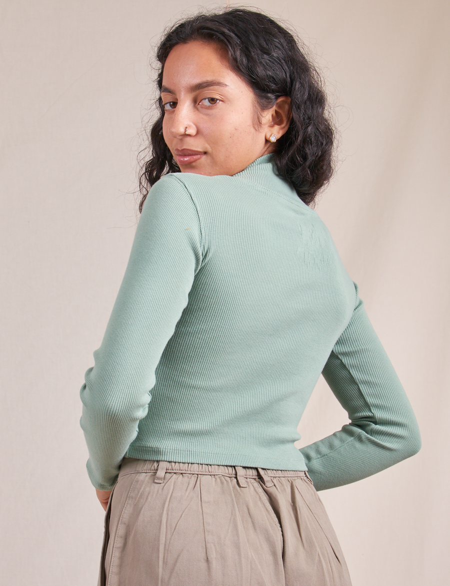 Angled back view of Essential Turtleneck in Sage Green worn by Blair