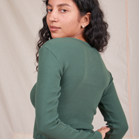 Angled back view of Long Sleeve V-Neck Tee in Dark Emerald Green worn by Blair