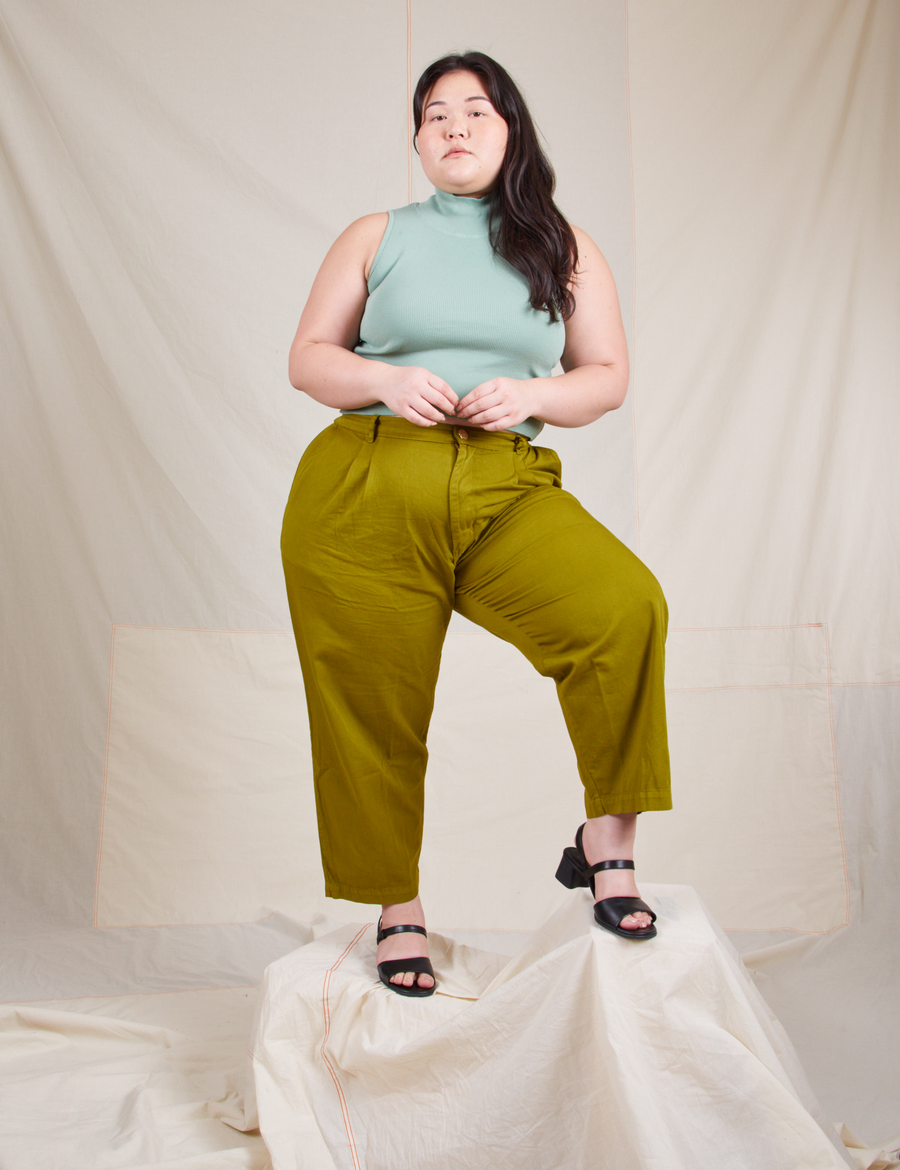 Sleeveless Essential Turtleneck in Sage Green on Ashley wearing olive green trousers