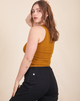 Angled back view of Tank Top in Spicy Mustard and black Western pants on Allison