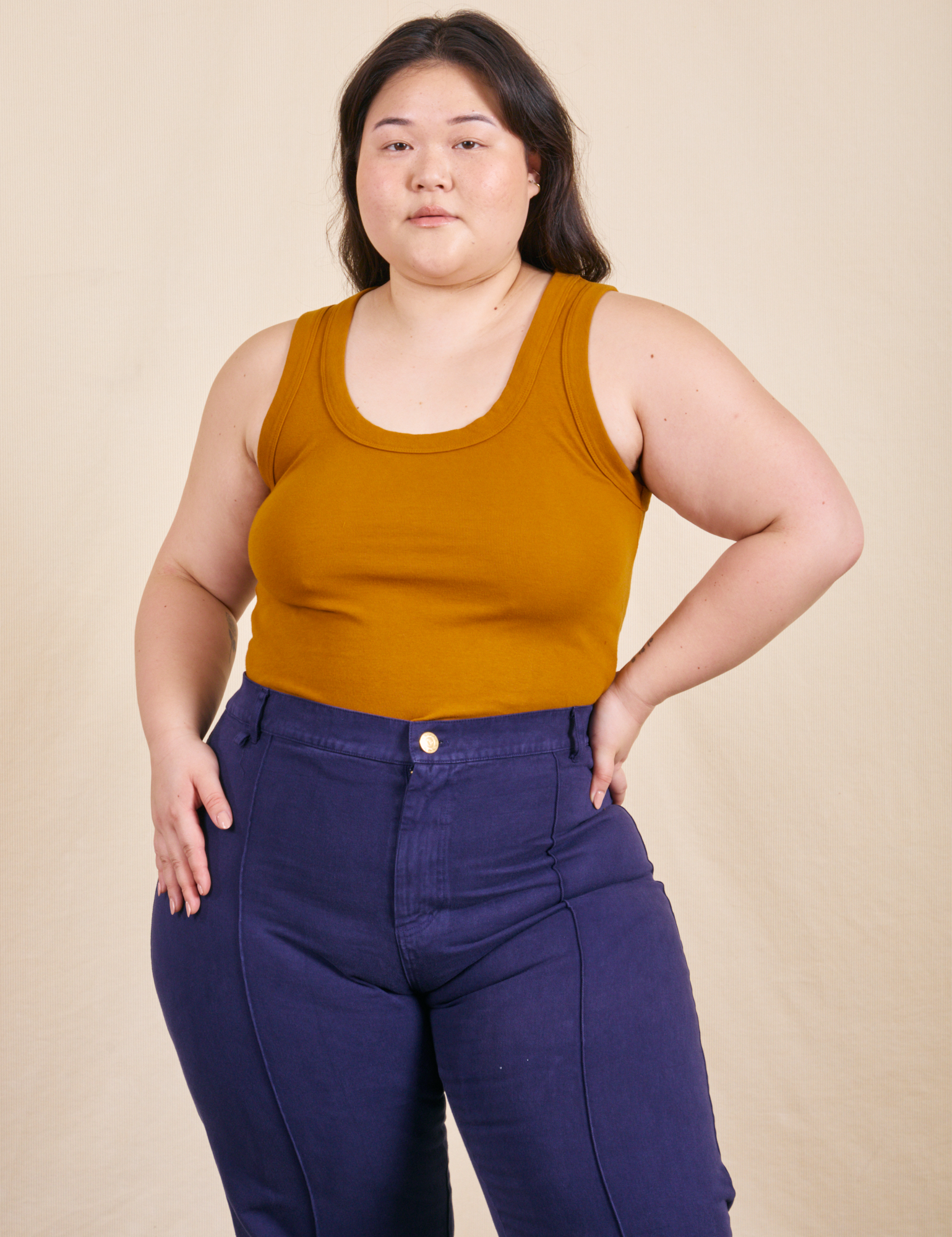 Ashley is wearing L Tank Top in Spicy Mustard paired with navy Western Pants