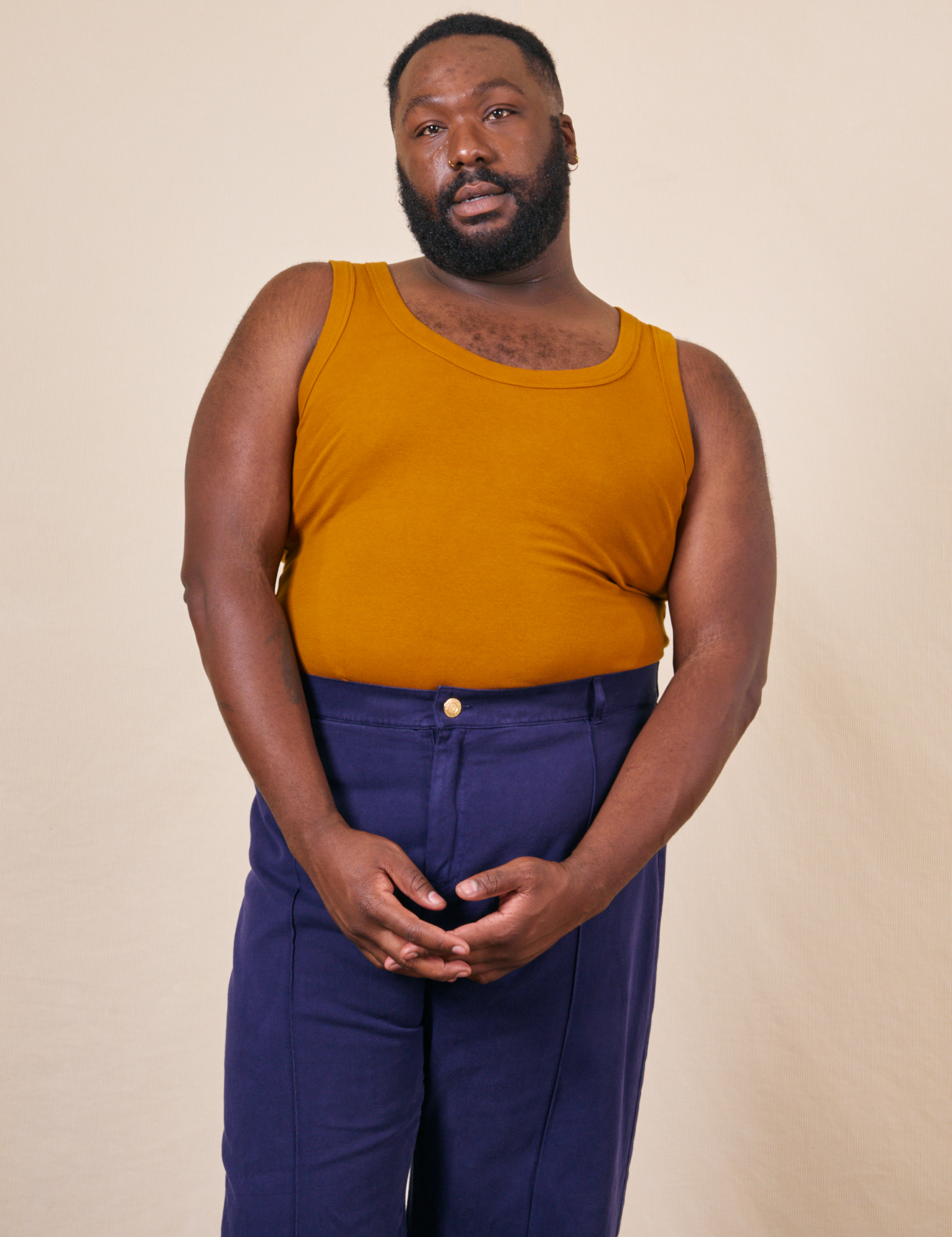 Elijah is wearing 3XL Tank Top in Spicy Mustard paired with navy Western Pants