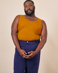 Elijah is wearing 3XL Tank Top in Spicy Mustard paired with navy Western Pants