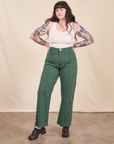 Sydney is 5'9" and wearing M Western Pants in Dark Emerald Green paired with vintage off-white Tank Top